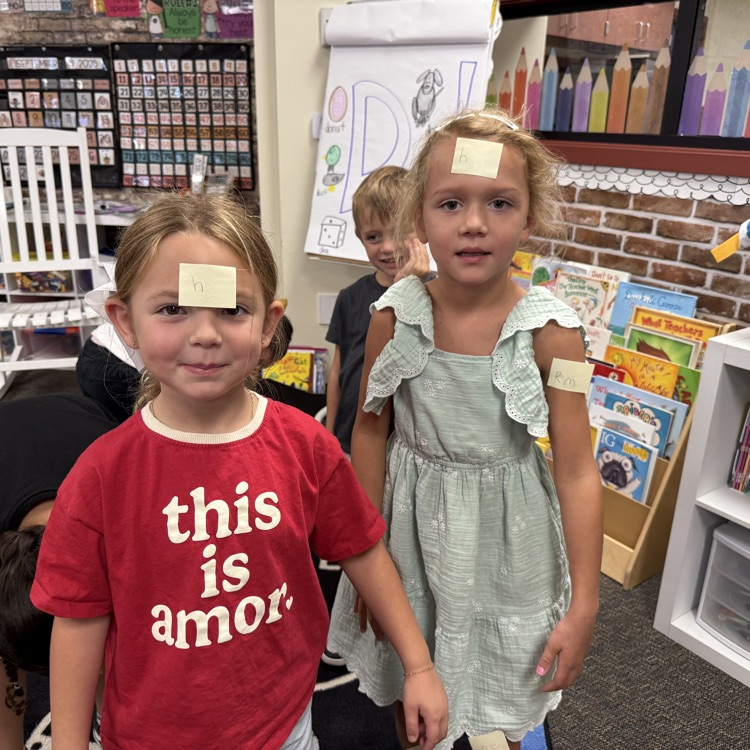 two little girls with sticky notes on their foreheads