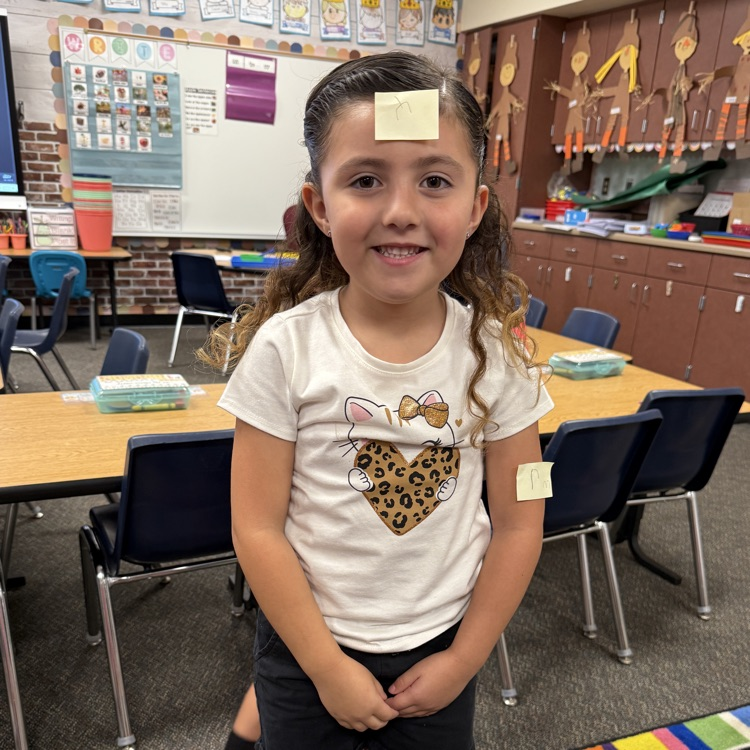girl with a sticky note on her forehead and left arm 