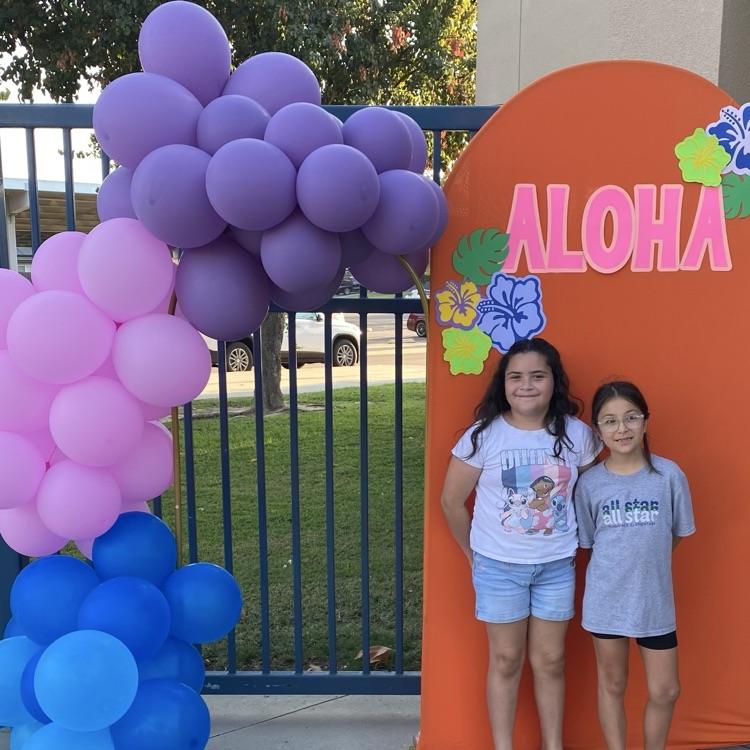 two girls if front of aloha sign with balloons