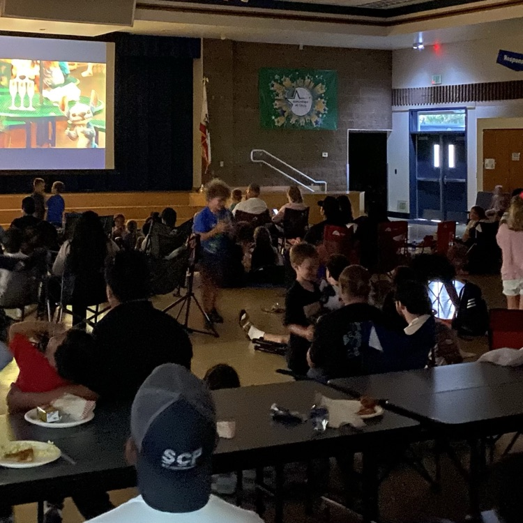cafeteria filled with families watching a movie