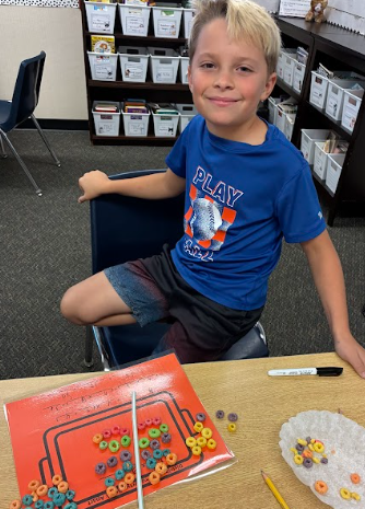 student with cereal doing math