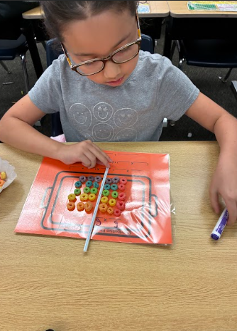 student with cereal doing math