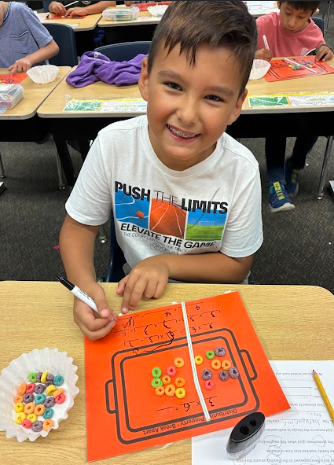 student with cereal doing math