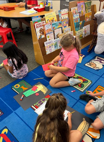 students cutting paper apples working on a math poster