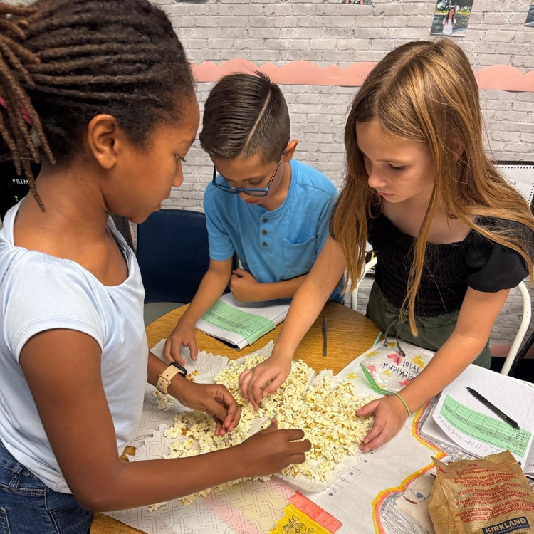 students working on an assignment with popcorn