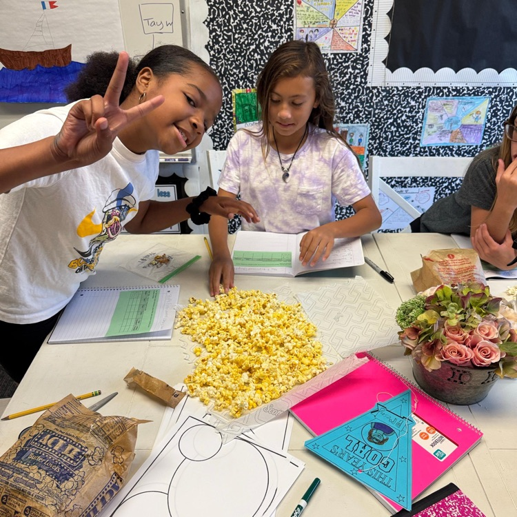 girl giving peace sign while working with popcorn