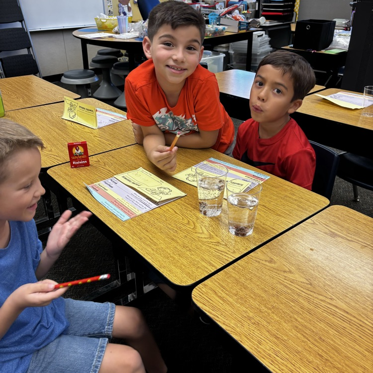 boys with cups of water doing an experiment