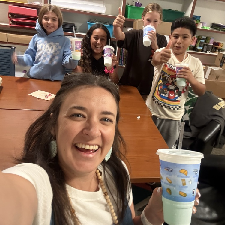 lady smiling with kids holding cups