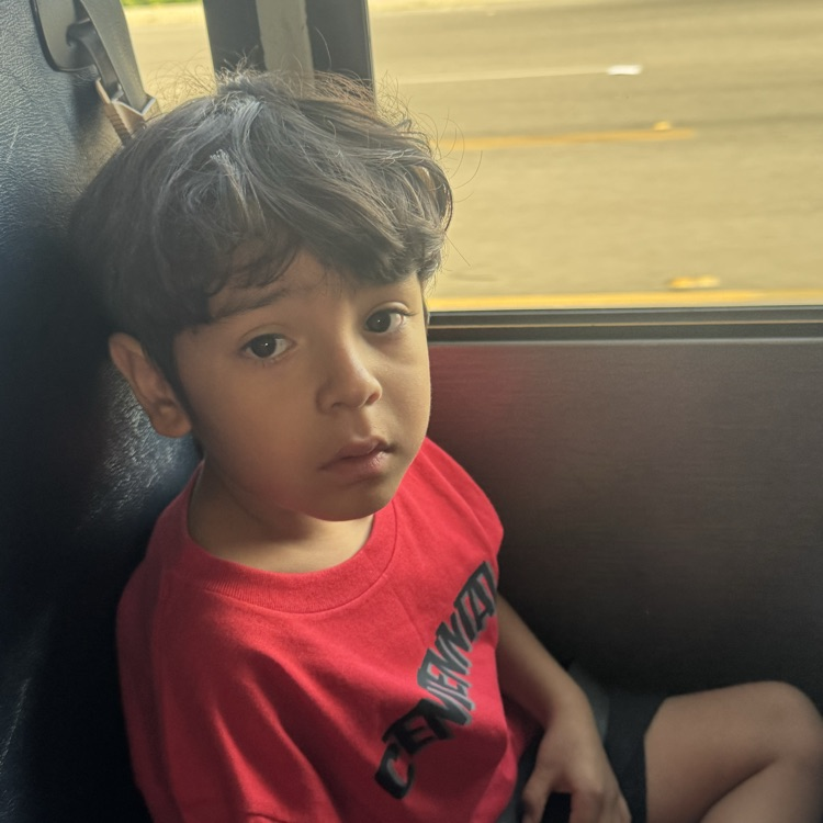 little boy sitting on school bus