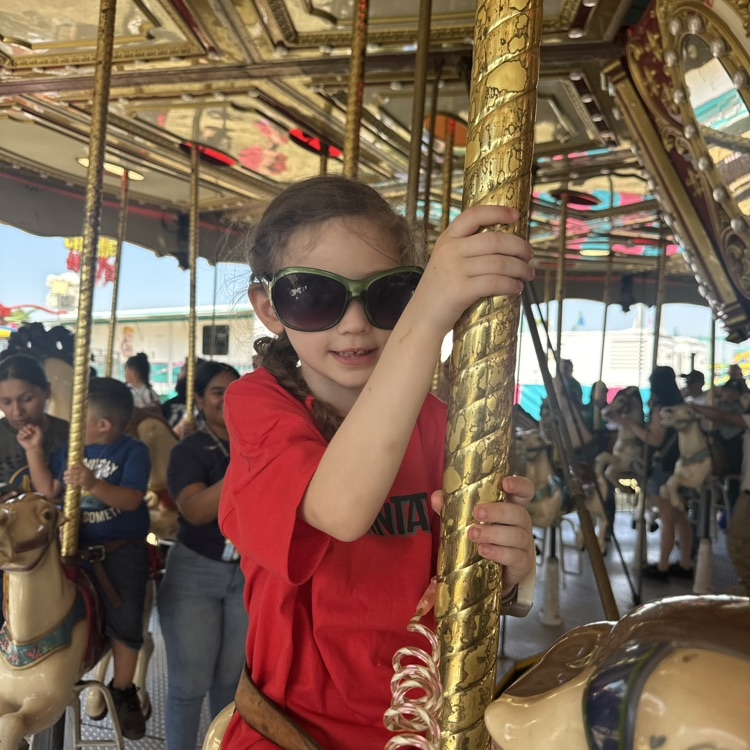 girl riding on the carousel