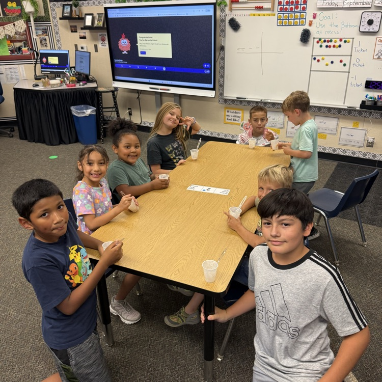 boys and girls smiling at a table
