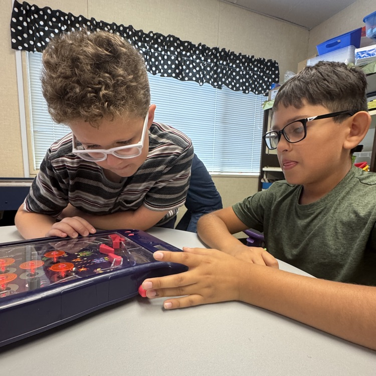 boys playing table pinball