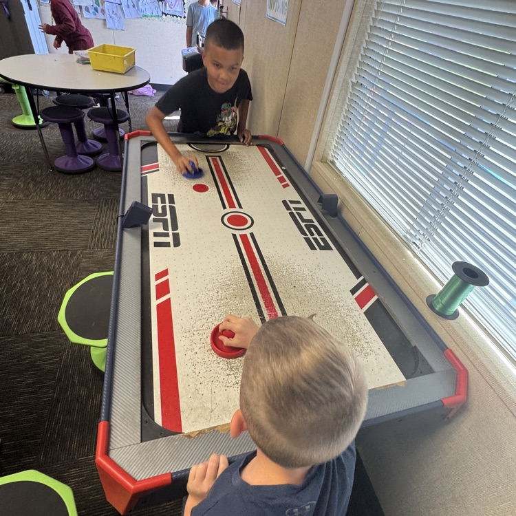 boys playing air hockey