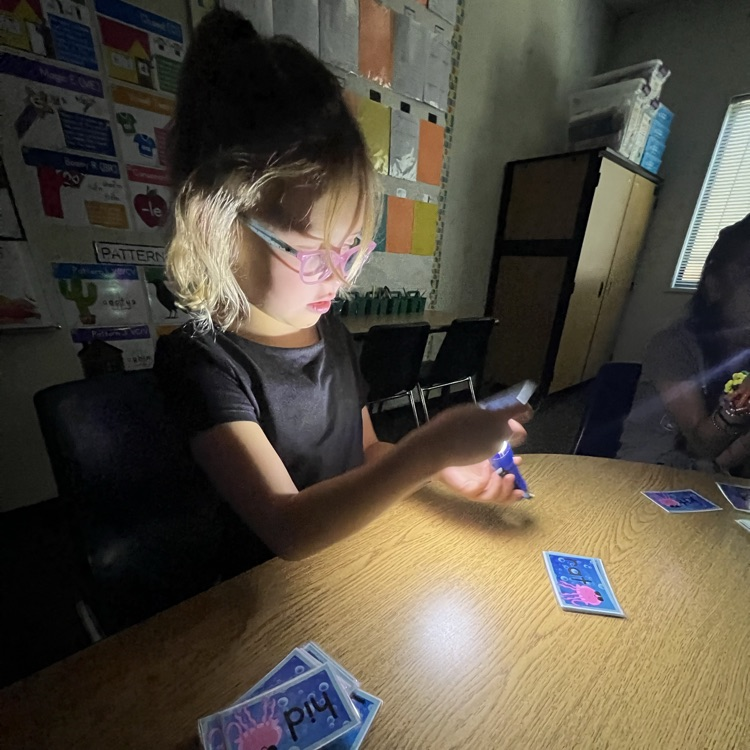little girl reading words with flashlight 
