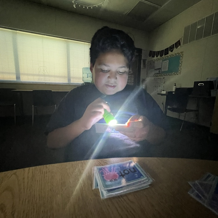 boy reading words with a flashlight 