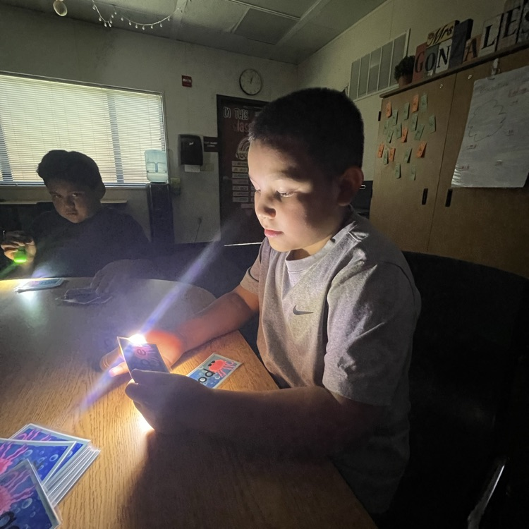boy reading flash card with flashlight