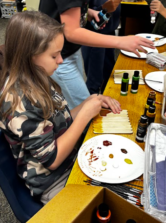students painting popsicle sticks