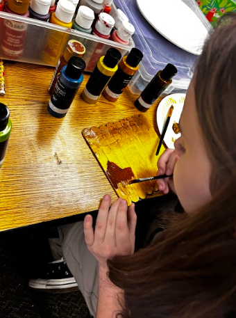 students painting popsicle sticks