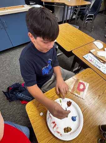 students painting popsicle sticks