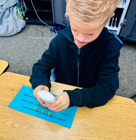student gluing pasta in a sentence representing a comma