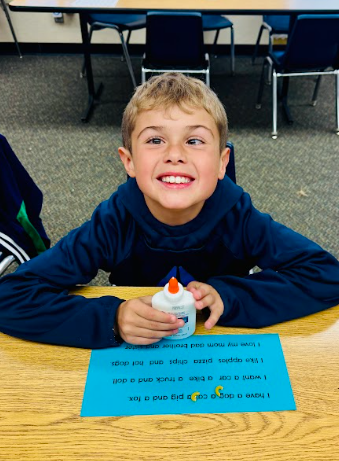 student gluing pasta in a sentence representing a comma