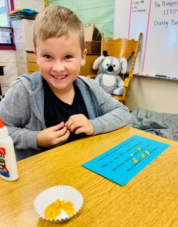 student gluing pasta in a sentence representing a comma