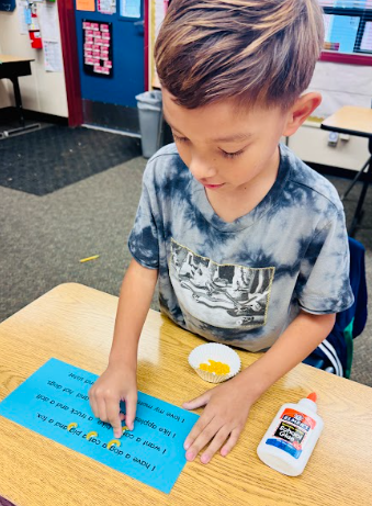 student gluing pasta in a sentence representing a comma