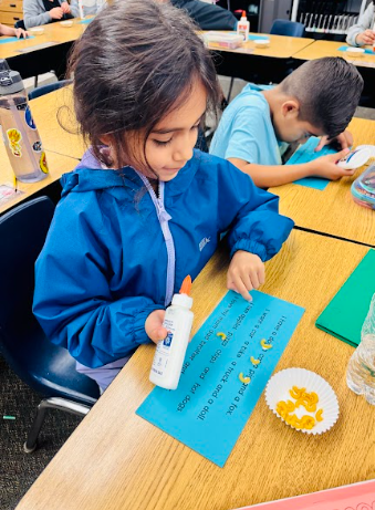 student gluing pasta in a sentence representing a comma