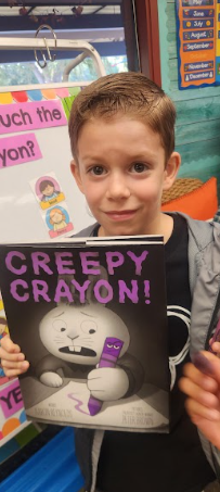 student with book creepy crayon