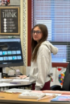student at teacher desk