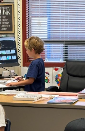 student at teacher desk