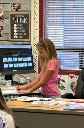 student at teacher desk