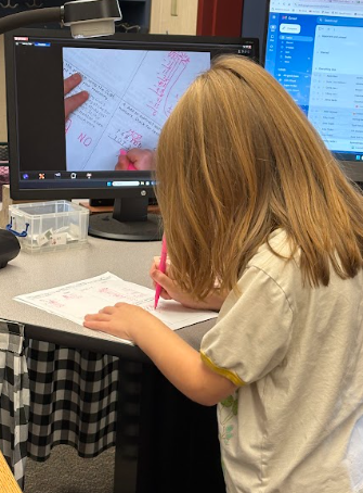 student at teacher desk