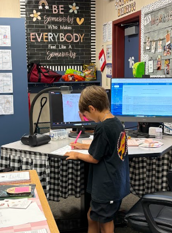 student at teacher desk