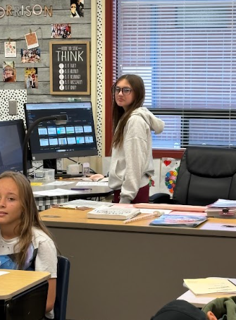 student at teacher desk