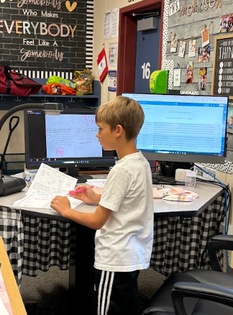 student at teacher desk