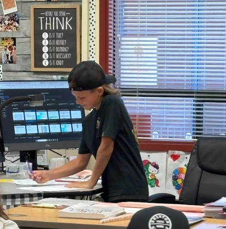 student at teacher desk