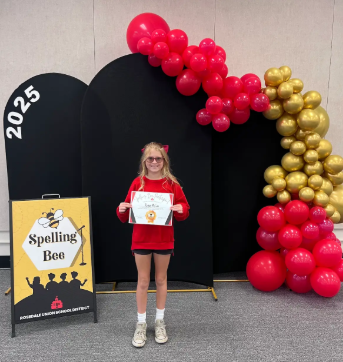 student with certificate in front of balloons