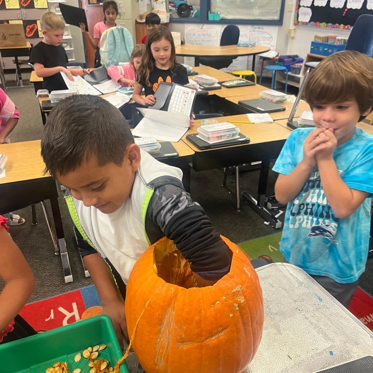 a boy cleaning out a pumpkin