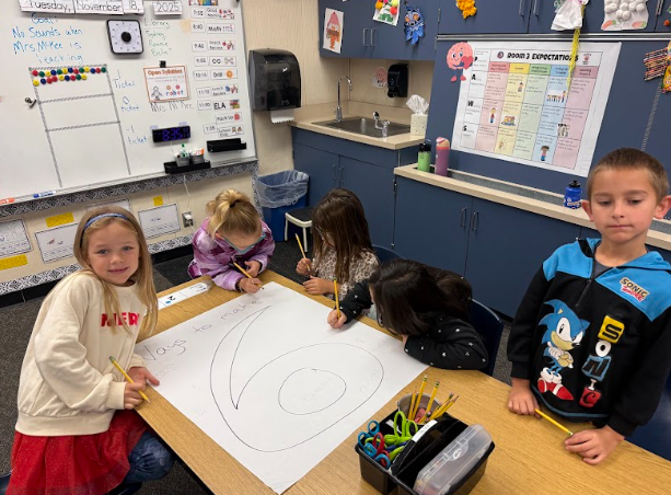 students working on a poster at a table