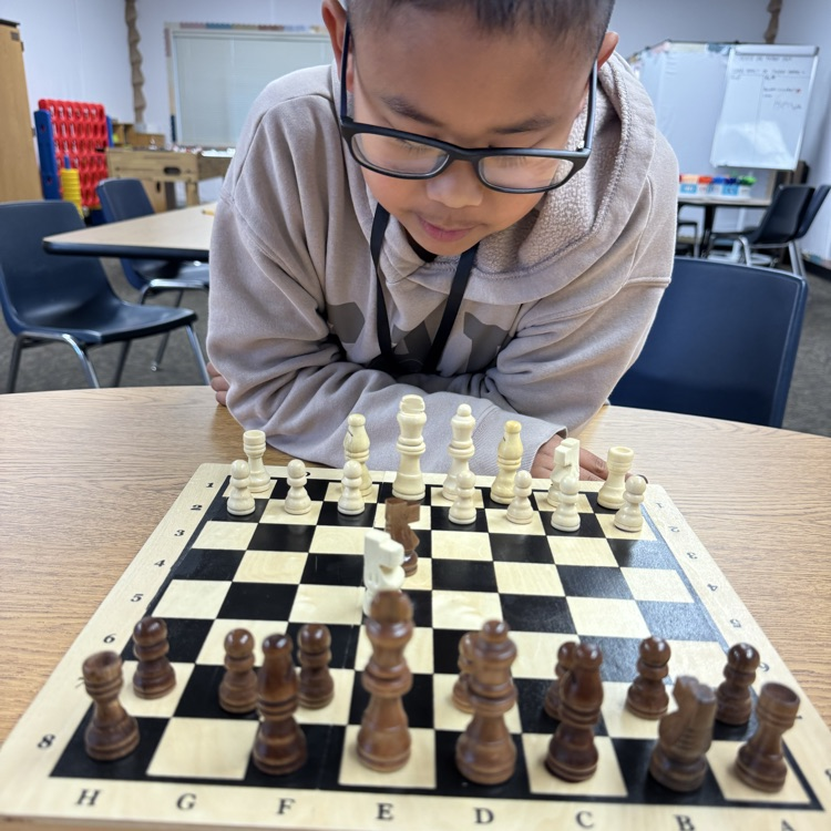 boy looking at a chess board