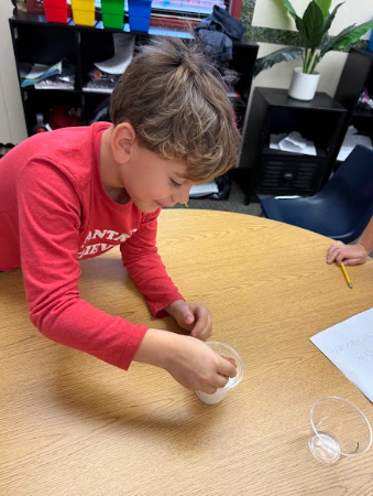 students observing gingerbread cookie floating in a liquid