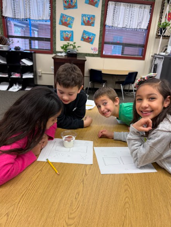 students observing gingerbread cookie floating in a liquid
