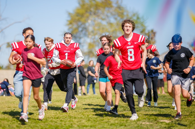 students running with football players