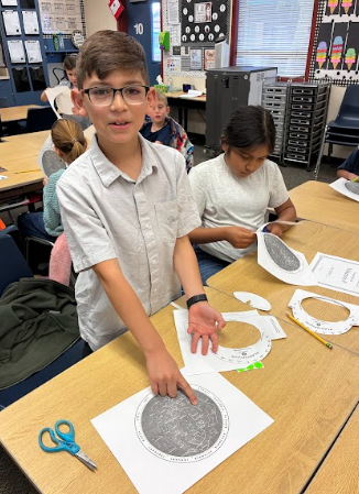 student holding a paper constellation viewer