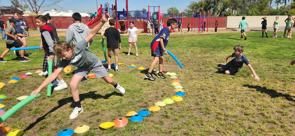 students on the field playing a game with noodles
