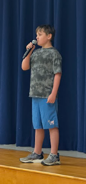 student singing on stage with a microphone