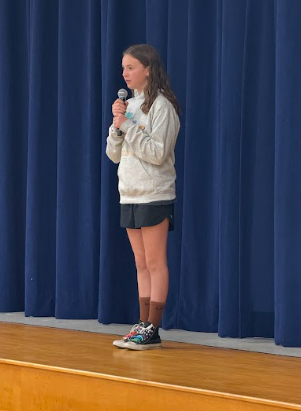 student singing on stage with a microphone