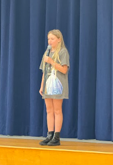 student singing on stage with a microphone