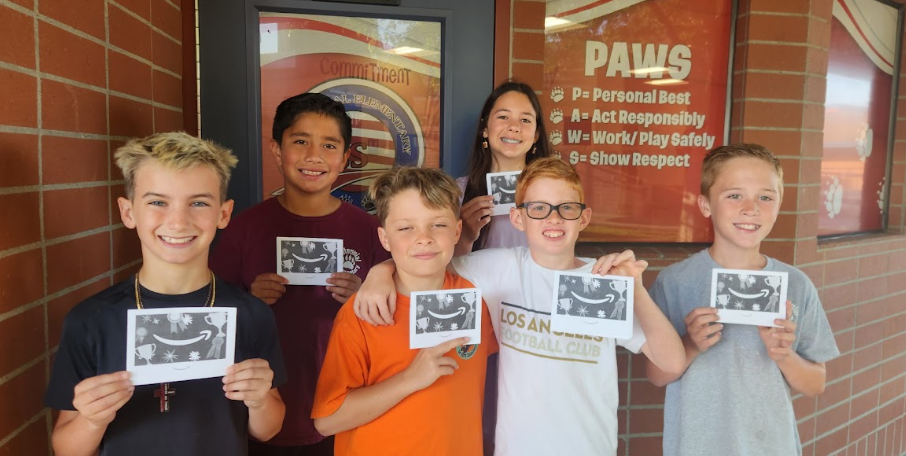 students holding up gift cards